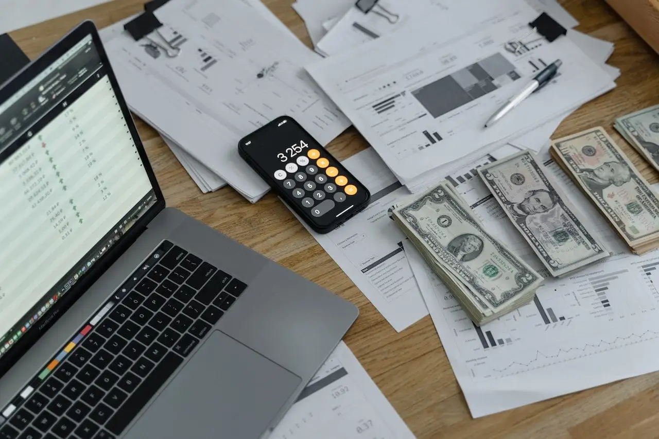 Banknotes, Calculator and laptop on Table